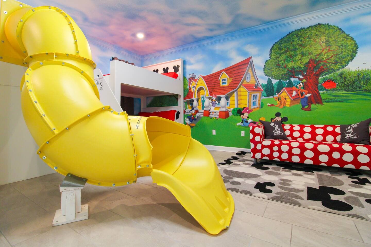Habitación infantil temática de Mickey con tobogán amarillo en una casa Dream Vacation Orlando