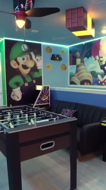 Sala de juegos con máquinas arcade y futbolín en una casa temática Dream Vacation Orlando